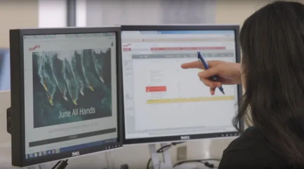 Distributed workforce: a woman is sitting infront of two computer screens