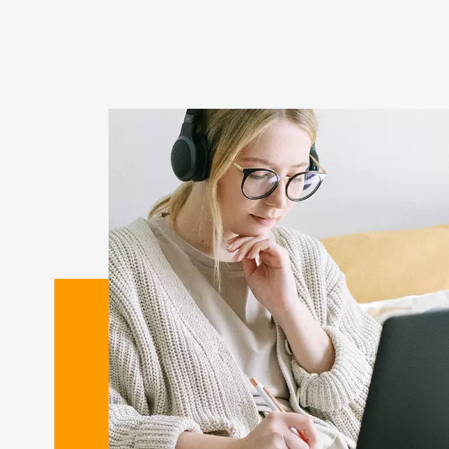 Remote employees - woman with glasses wearing headphones and using laptop computer