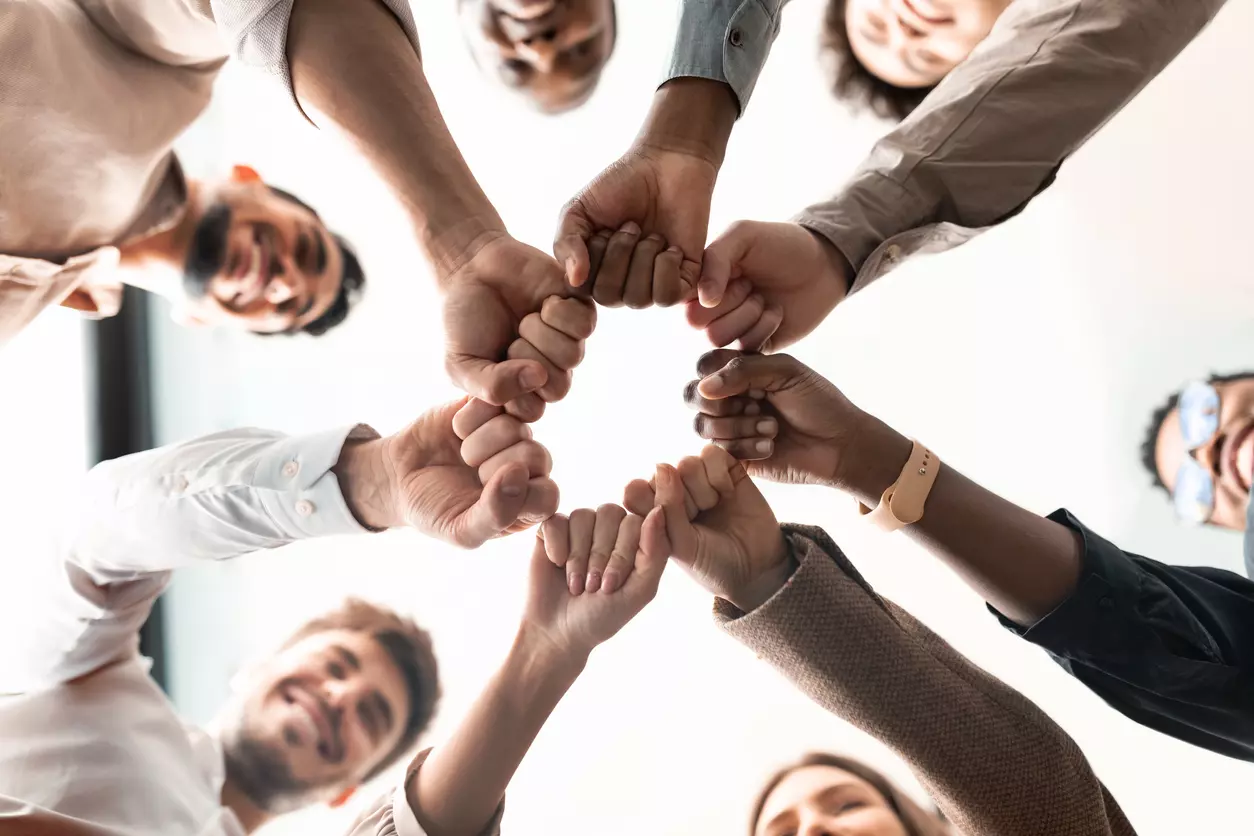 Employee retention: a group of employees fist bumping in a close setting