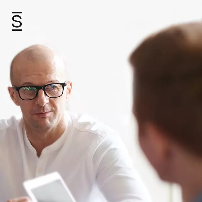 Intranet - man with glasses speaking with male colleague