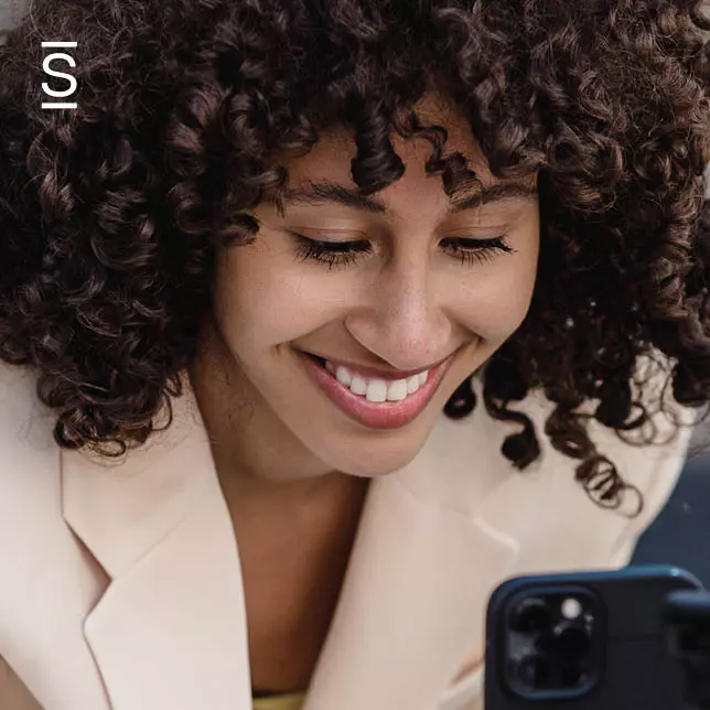 Corporate communications - smiling woman looking at smartphone screen