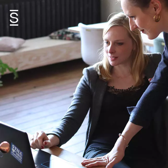 Internal communications success - two female employees looking at computer screen