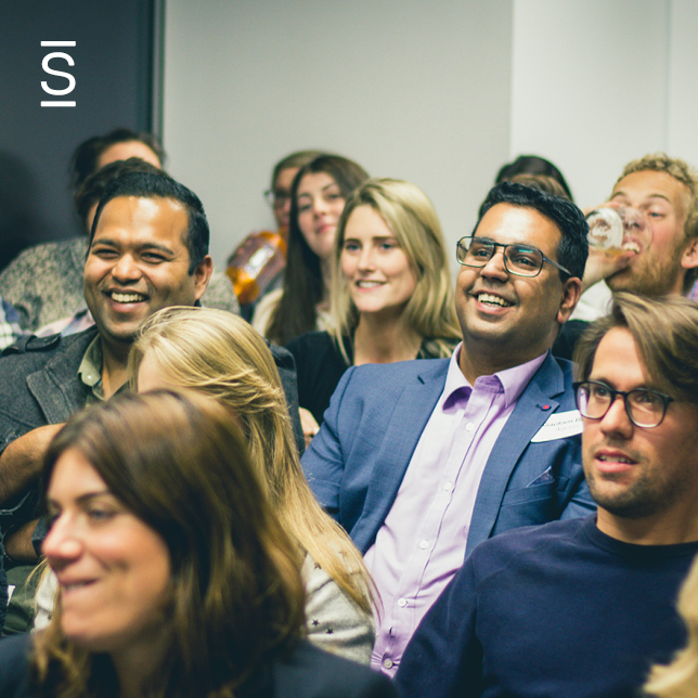 Employee experience - wideshot of a group of people listening to an unseen speaker