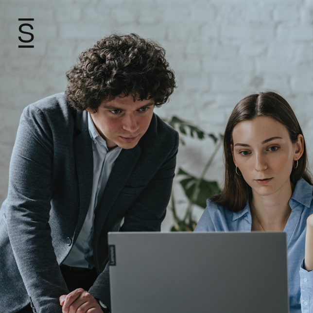 Engage employees - man in suit and woman in blue shirt looking at laptop computer