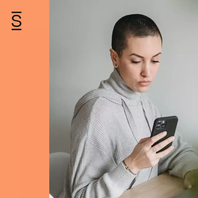 Social intranet - woman in grey sweater looking at smartphone