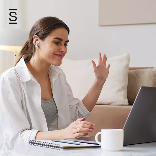 Social intranet adoption - woman in white shirt waving at computer screen