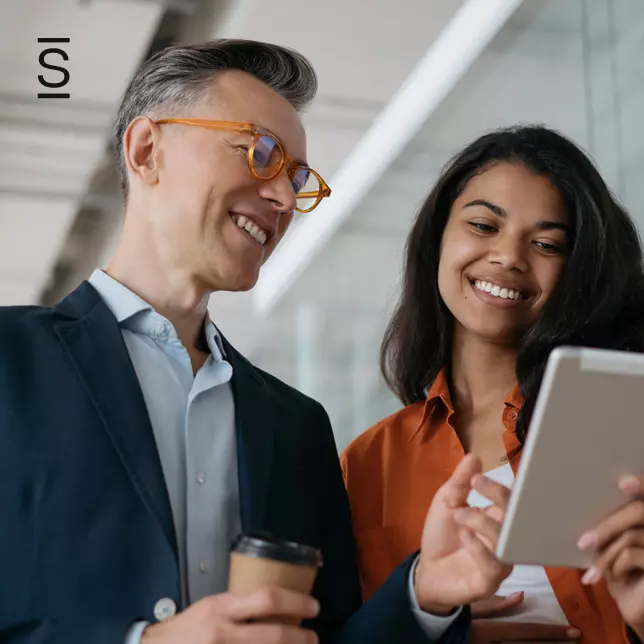 Corporate culture - man with glasses and woman looking at tablet computer