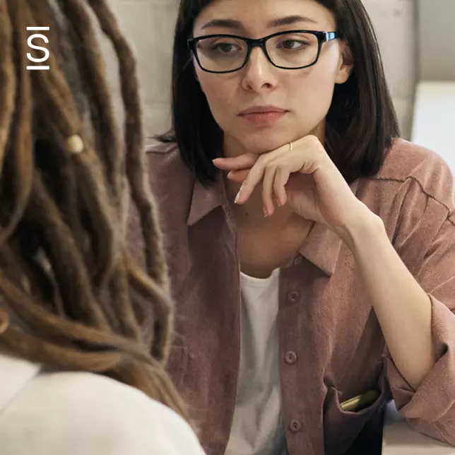 Internal communications - woman with glasses listening to female colleague