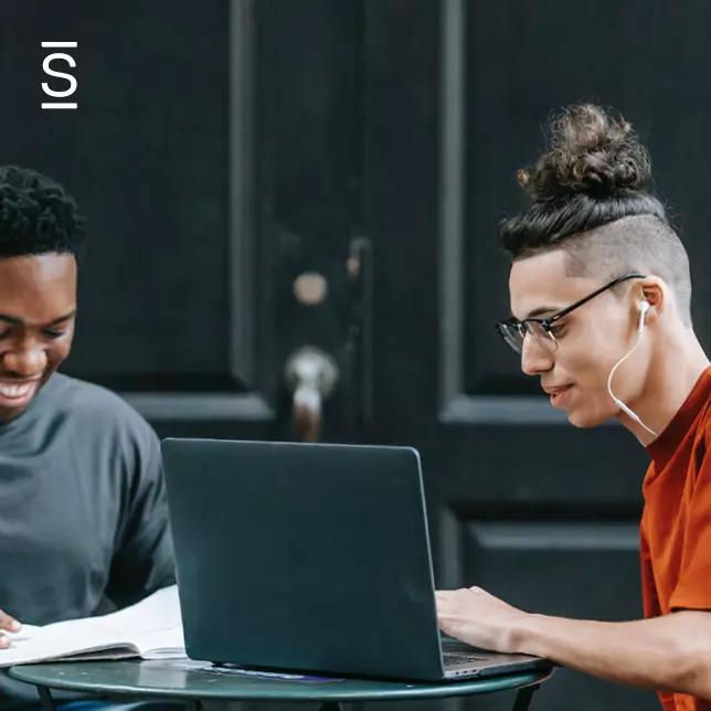 Employee engagement - two employees working together in front of a laptop