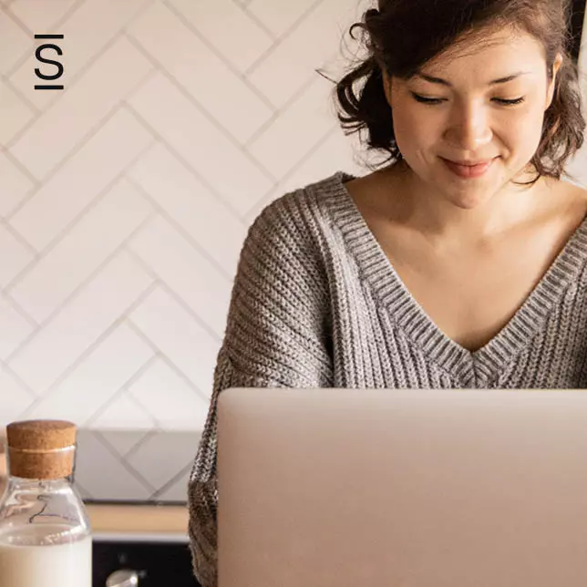 Work From Home - woman with slight smile looking at laptop screen