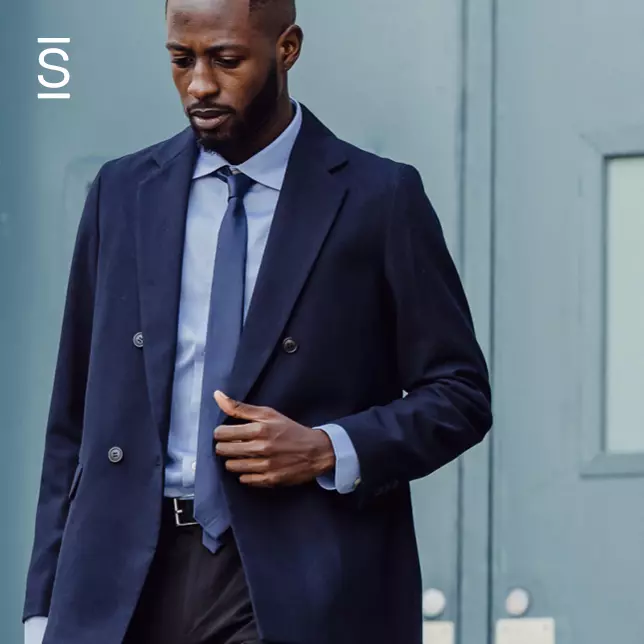 Leadership - man in suit walking away from office building