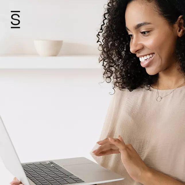 Intranet - woman smiling and using laptop computer