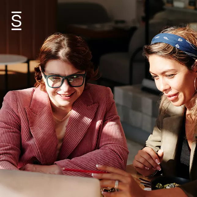 Intranet content - two female employees looking at a laptop screen