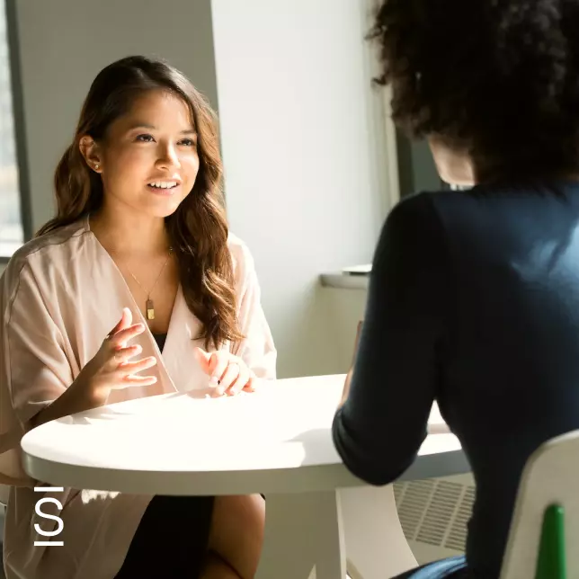 Virtual water cooler - two female employees sitting across from each other and having a conversation