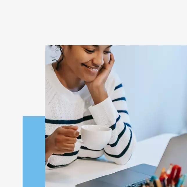 Digital workplace - woman holding coffee cup and smiling while looking at laptop screen