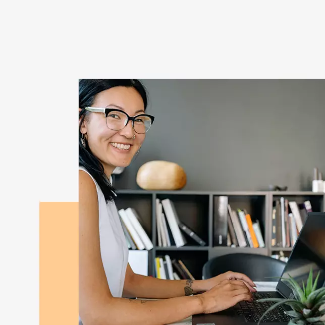 Remote work - smiling woman with glasses using laptop computer