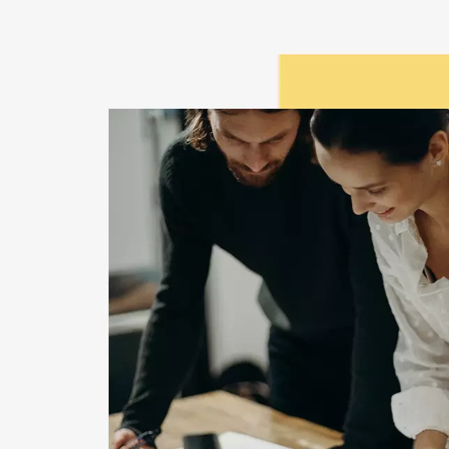 Effective communication - two employees looking at an unseen computer