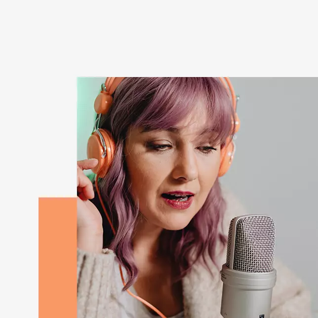 Internal comms - woman with light pink hair wearing headphones and speaking into microphone