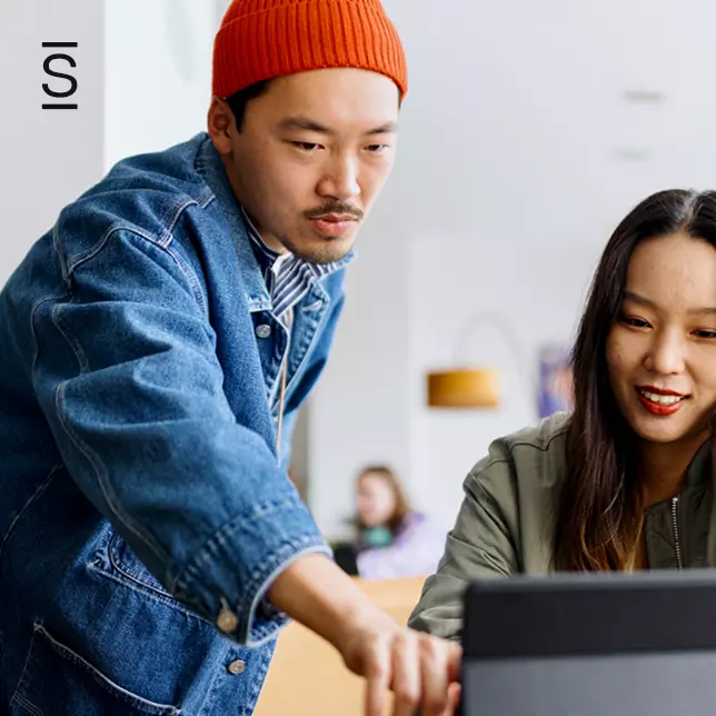 Breaking IT dependence - two employees working together at laptop