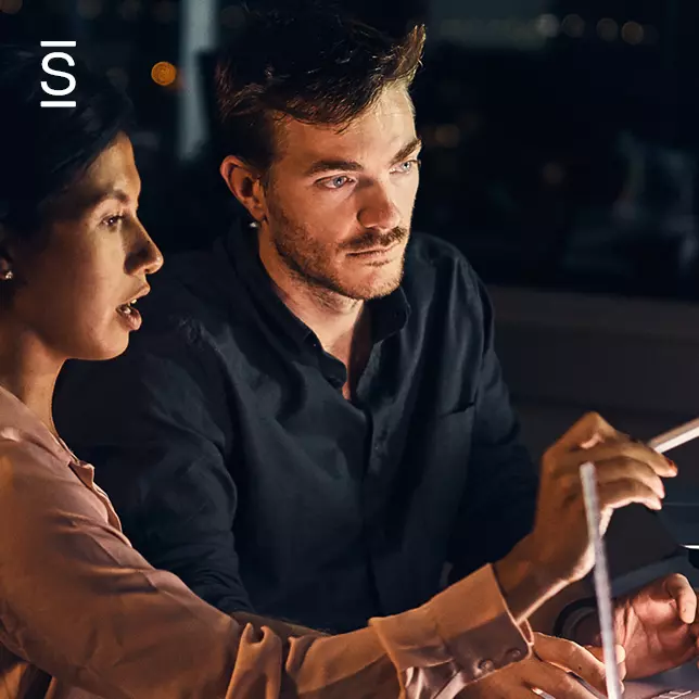 Collaboration in the workplace - male employee and female employee working at a computer screen