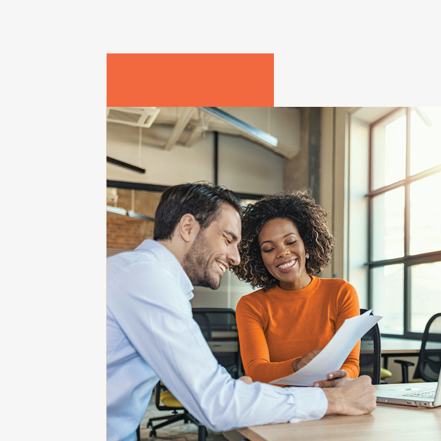 Professional development - male and female employees looking at sheet of paper at a table