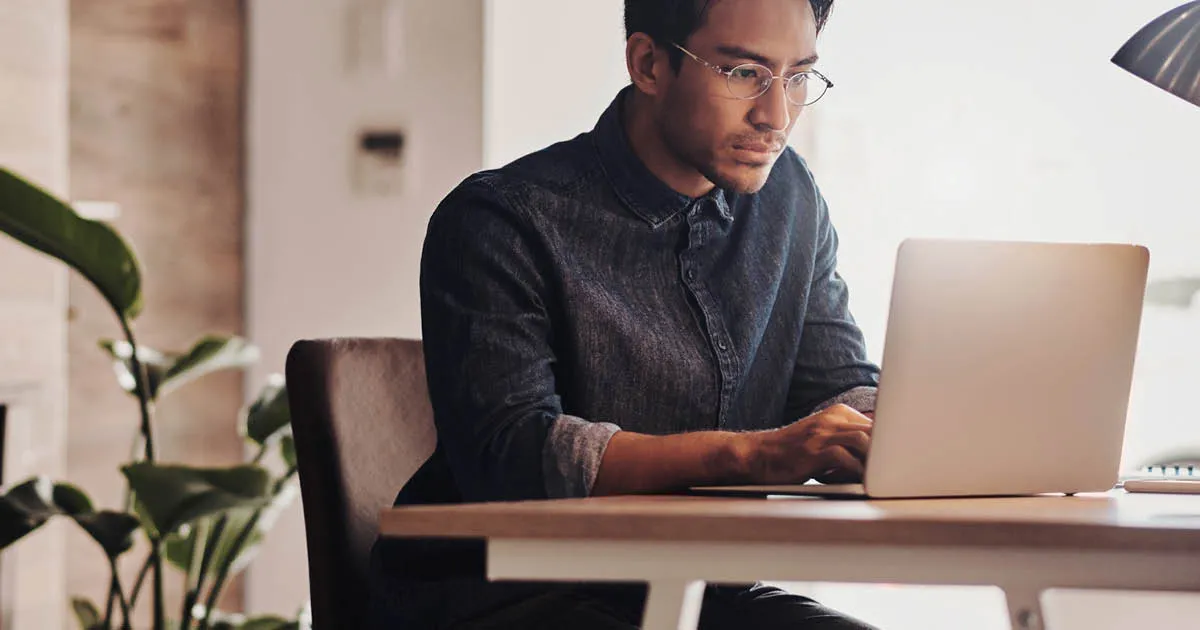 Employee handbook guide - man reading handbook on laptop computer