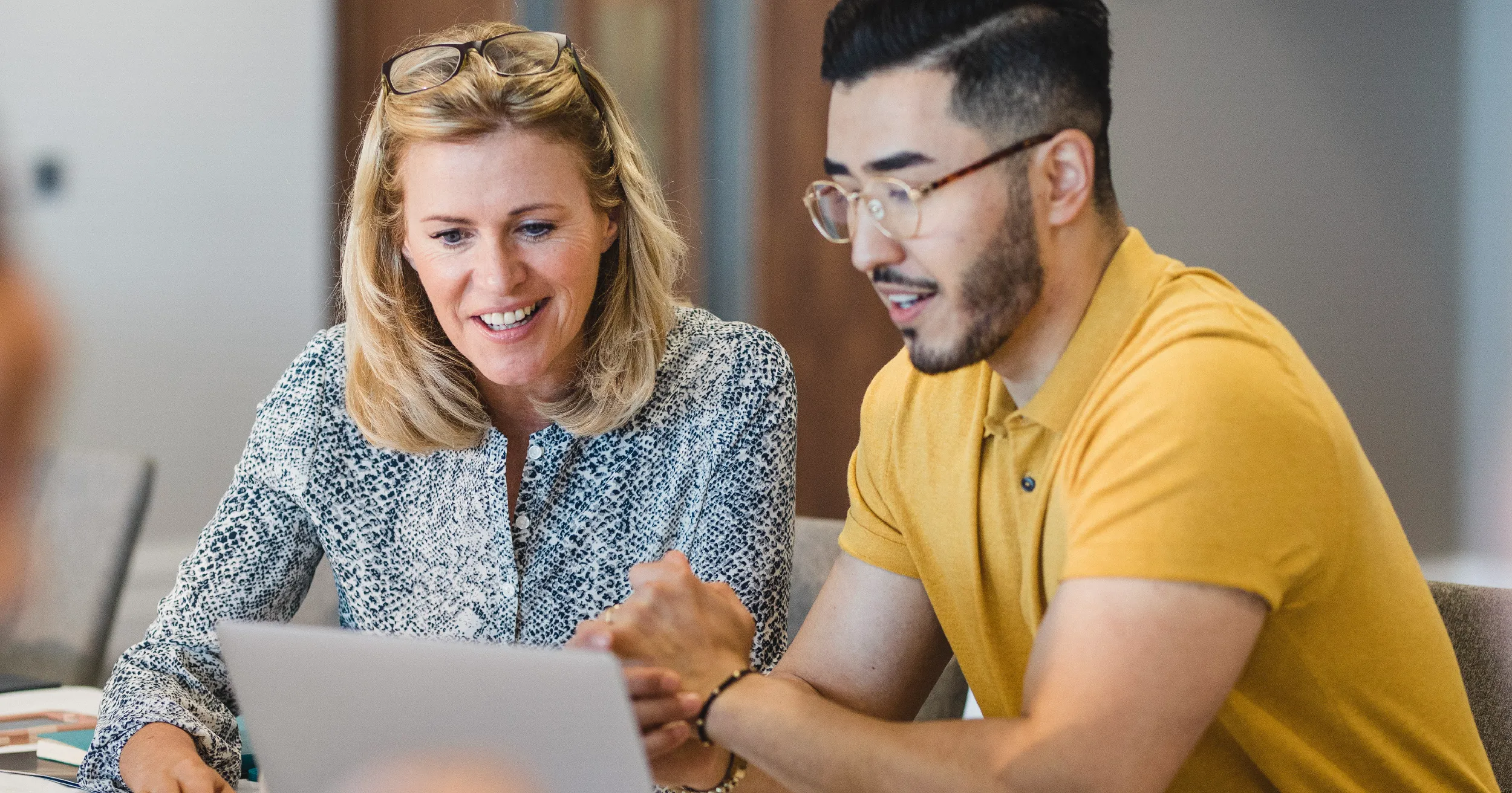 Editorial calendar - male employee and female employee looking at sheet of paper together