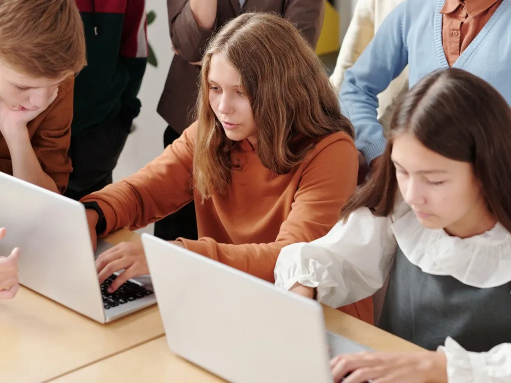 Good leadership - two girls using laptops in classroom