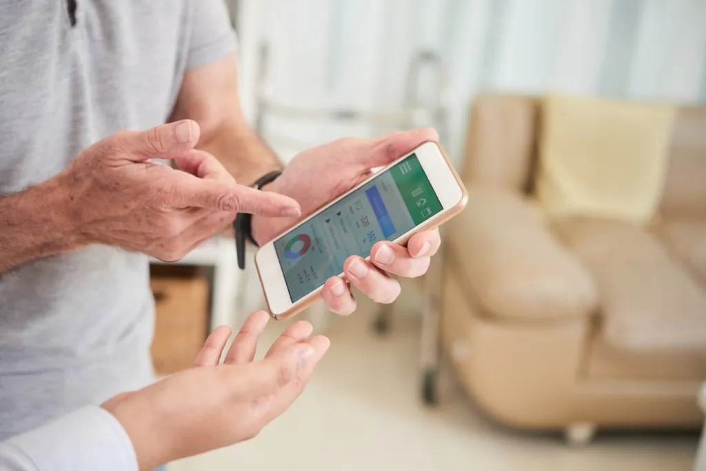 Recruitment and retention - elderly man consults with his doctor about health data shown on smartphone screen