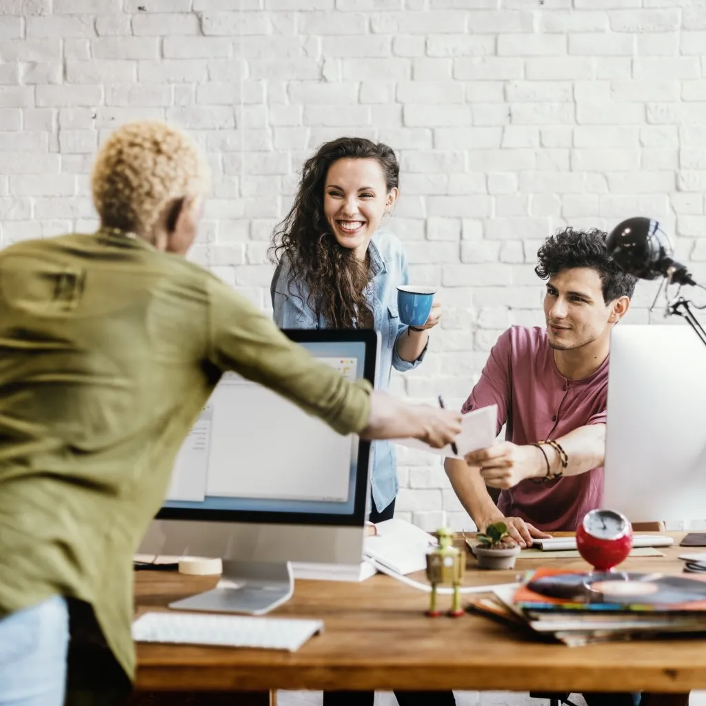 Build or buy intranet - team of employees working together at a table filled with computers