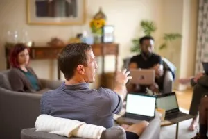 Employee retention - hybrid team sitting with laptop computers and collaborating