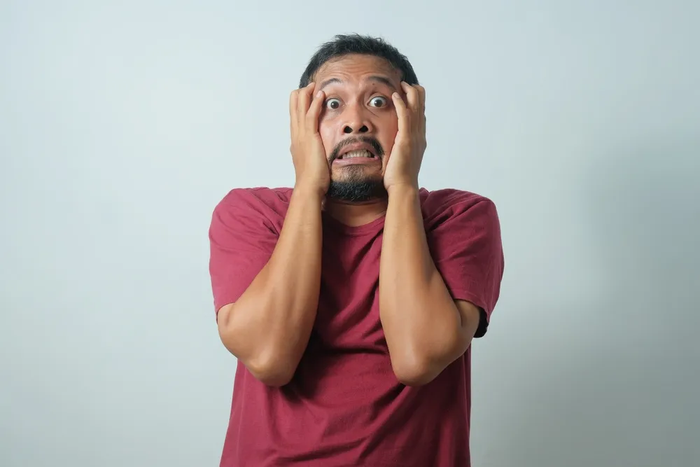 Change management - man with a nervous expression on his face in front of white background