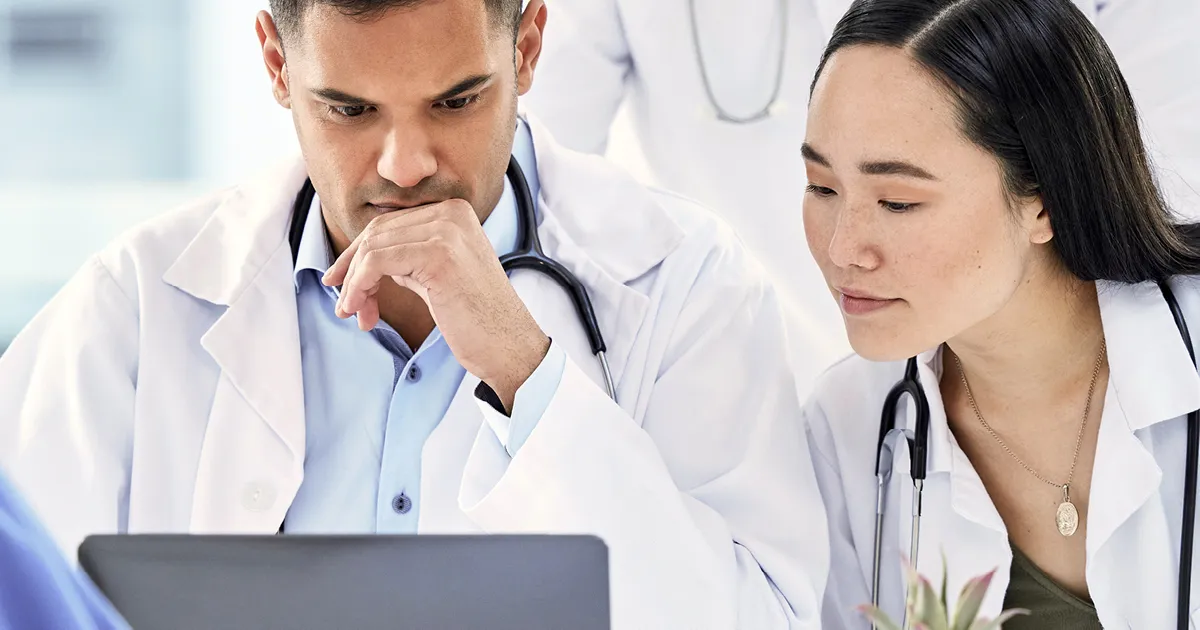 Empowering leaders - male and female doctors looking at laptop screen