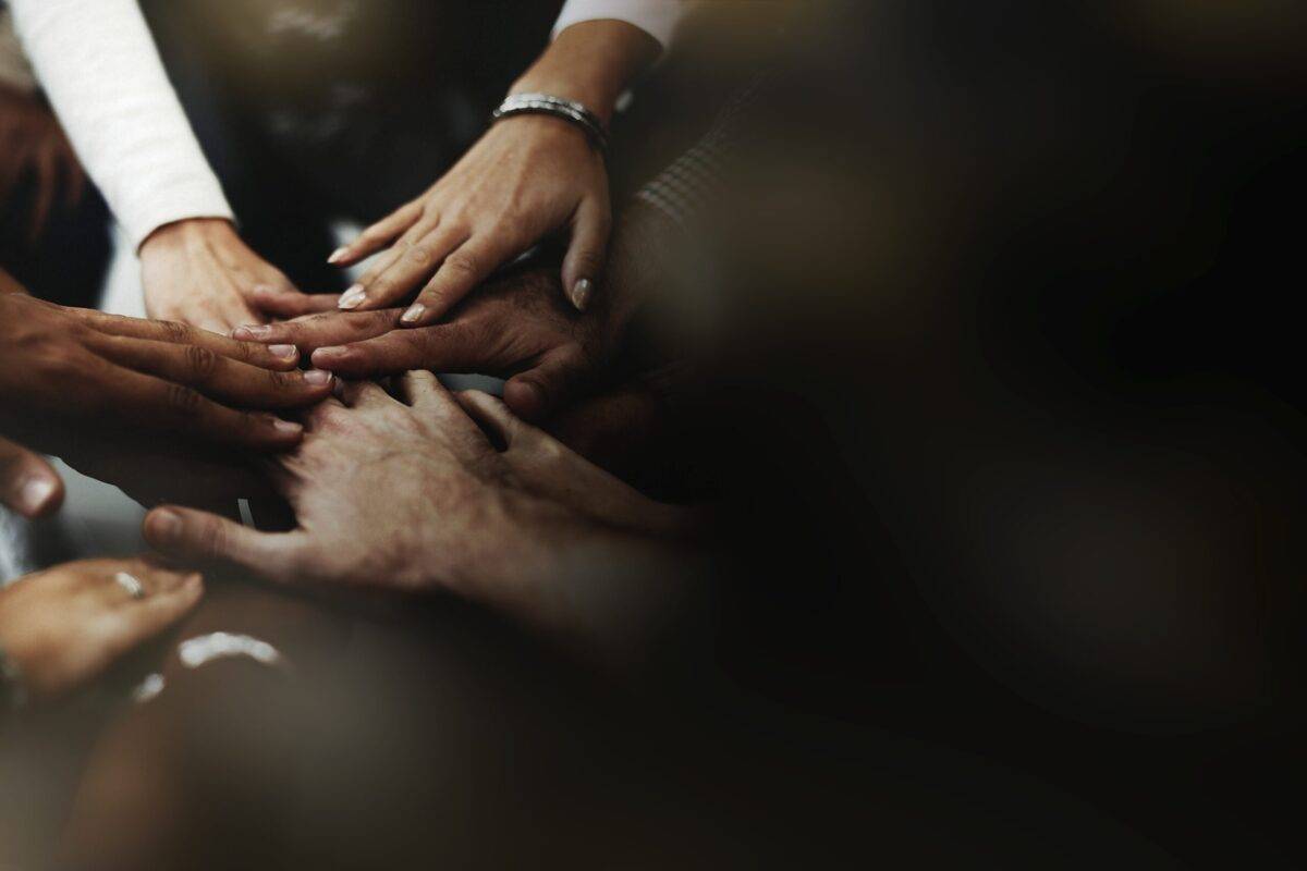 Corporate social responsibility: a group of individuals stacking their hands together